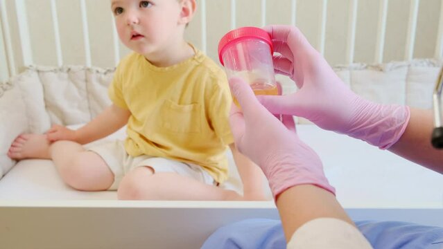 The pediatrician instructed on how to collect a urine sample at home from her sick baby for diagnostic analysis. Kid aged about two years (one year eleven months)