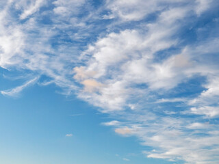 Blue sky during sunset with cumulus, white clouds that have patches of orange or pink clouds옅은 주황색 또는 분홍색 구름이 있는 일몰 때의 푸른 하늘 