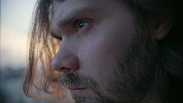 Serious man. Brave, overcome concept. Bearded long hair. Motivation man, Willpower. Strong motivated man. Pensive man. Sunset, sunrise city