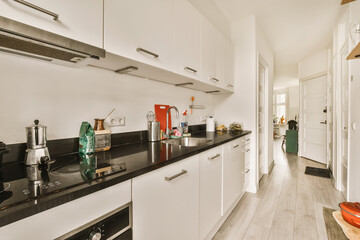 a kitchen area with white cabinets and black counter tops on the counters in this room is very...