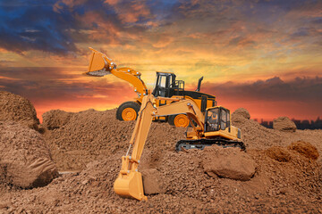Wheel loader and Crawler excavator are digging the soil in the construction site. on the sunset...