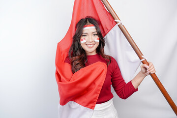 Happy smiling Indonesian woman holding Indonesia's flag to celebrate Indonesia Independence Day...