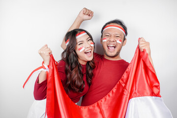 A young Asian couple with a happy successful expression wearing red top and headband while holding...
