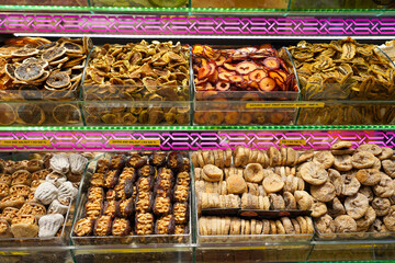 Piles of dried fruit, herbals, sweets, pastries, and various processed foods on display in a gift shop at a Turkish market