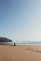 Surfer meditating on beach in the late afternoon. 