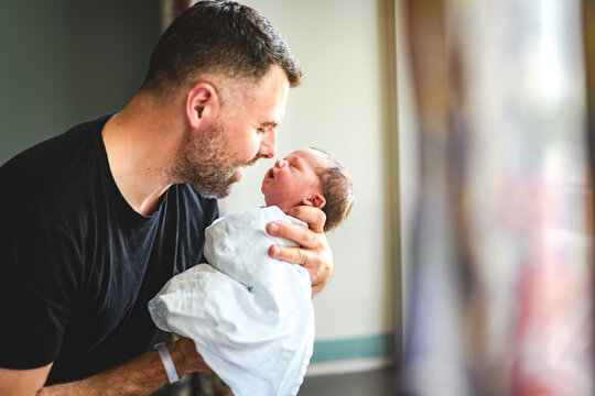 New born baby boy resting in father arms