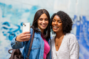 two female friends taking selfie with smart phone