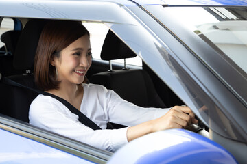 Asian woman driving a car and smile happily with glad positive expression during the drive to travel journey, Female enjoy laughing transport and relaxed on road trip vacation concept