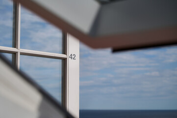 Geöffnete weiße Balkontür mit einer aufgeklebten Zahl 42 hinter einem geöffneten Dachfenster...