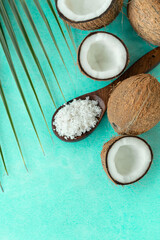 Fototapeta na wymiar Creative coconut advertising poster image with coconut flakes on aqua colour background, coconut pieces with palm leaf image