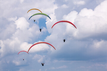A group of colorful paragliders in the sky in Ebanalp, Switzerland
