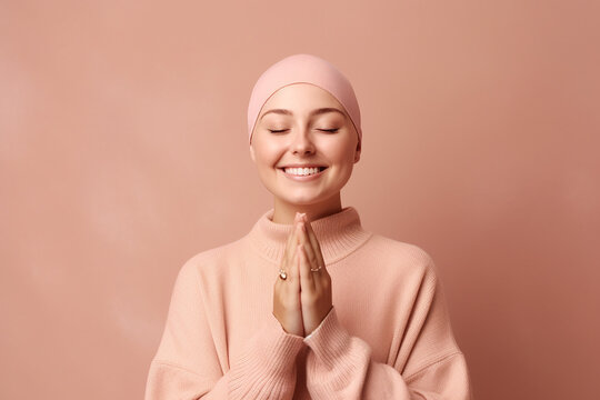 Girl in a pink scarf on her head smiles with her palms together