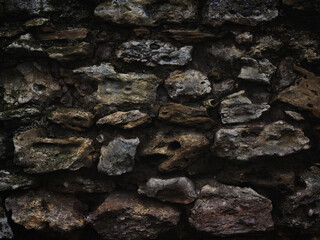 old wall of rough stones as dark vintage background