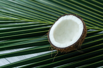 Half cut coconut isolated on palm leaf