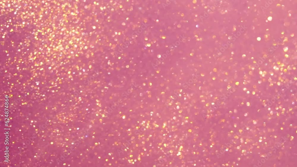 Wall mural abstract gold particles on pink background. gold particles in liquid float and glisten. sparkling go
