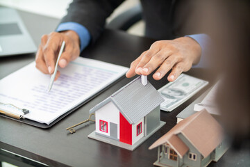 real estate agent is handing over home to customer after selecting home and negotiating sales contract with the real estate agent. The concept of buying home from reliable real estate agent