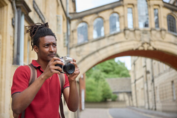 Young Man Travelling On Vacation Taking Photo With Camera When Sightseeing In Oxford