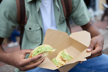 Close Up Of Young Man Eating Taco At Outdoor Street Food Stall