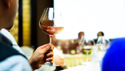 Unrecognizable man holding  glass of red wine at dinner