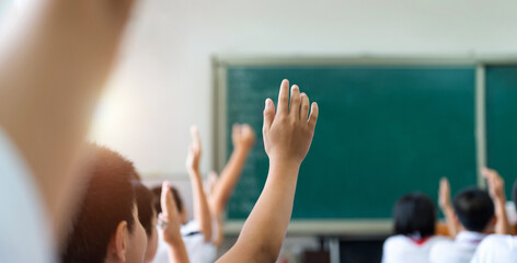 Group of raised hands in class of middle school