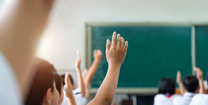 Group Of Raised Hands In Class Of Middle School