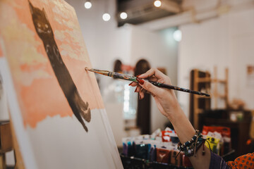 Close-up of female artist painting on canvas with brush Young painter working on the floor of her art studio creative young woman painting with oil paints creative concept