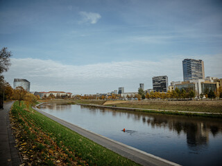 Fototapeta premium Neris River with the modern buildings of the new city center (southern Snipiskes)
