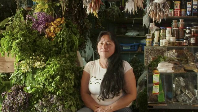 Portrait of Pretty smiling woman herb seller in a traditional market in Merida Venezuela. South America. Looking at camera.