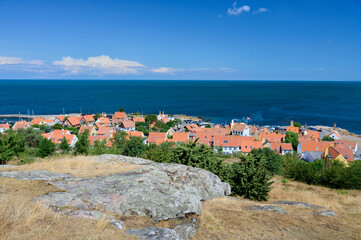 Blick auf rote Dächer der dänischen Ortschaft Gudhjem auf der Ostsee Insel Bornholm an einem sonnigen Mittag