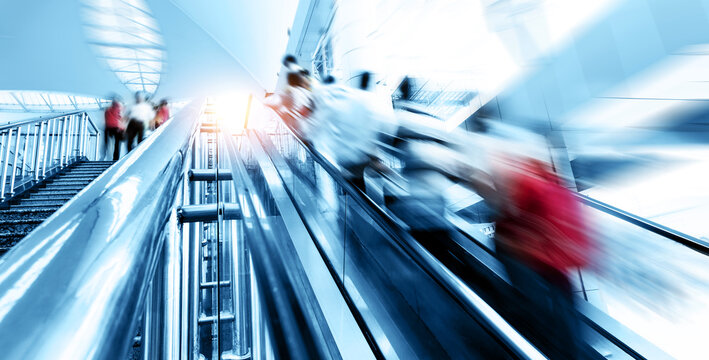 People rush on escalator motion blurred