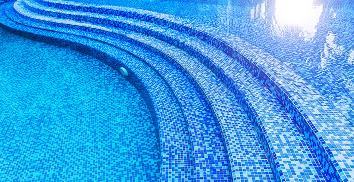 Steps in the swimming pool with blue ceramic tile mosaic