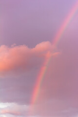 landscape with rainbow and pink cloud on cloudy evening sky