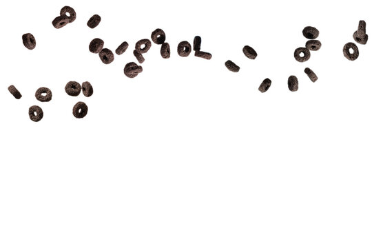 Chocolate rings cereal spill out into a bowl. Breakfast.