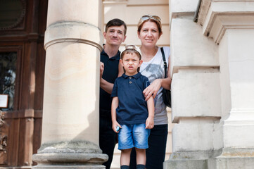 A family on an excursion in a big city - a little boy, dad and mom, the boy is tired and wants to go home, he is not interested in the museums and attractions that parents are interested in