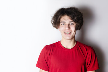 A young teenager boy smiles beautifully, he has temporary plastic braces on his teeth, the metal braces broke and they were temporarily installed with plastic braces