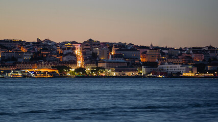 View of Lisbon city from Cacilhas at dusk; Concept for travel in Portugal and visit Lisbon