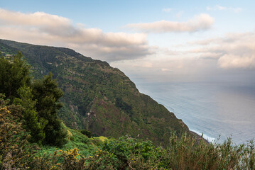 Fototapeta na wymiar Atlantic Ocean with steep partly rocky hills above in northwestern coast of Madeira island