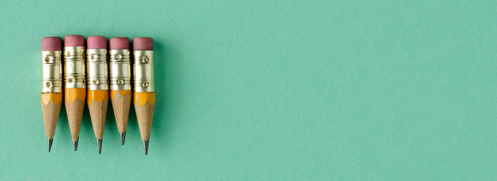 Five mini wooden pencils on a blue background. Back to class. Copy space. Top view.