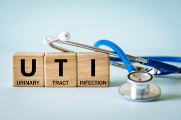 Medical stethoscope and wooden blocks with the medical abbreviation UTI for Urinary Tract...