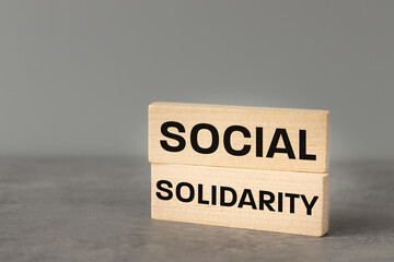 Social Solidarity, Wooden blocks with words "Social Solidarity" Beautiful gray background, The concept of community building and activities for the local community, Help for the weakest, copy space