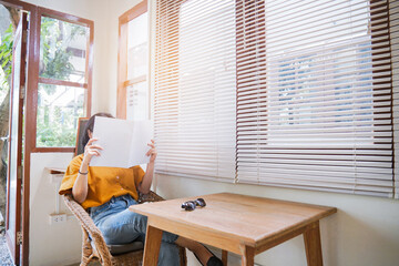 Close up teenage girl holding and reading book or magazine with cement wall in reading room, copy space concept.