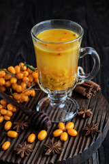 Glass cup of sea buckthorn tea on  dark background