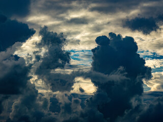 Dramatic summer evening sky with ragged clouds, a large drifting silhouette, and a variety of wind and light effects in southwest Florida, for concepts of unrest, uncertainty, transition