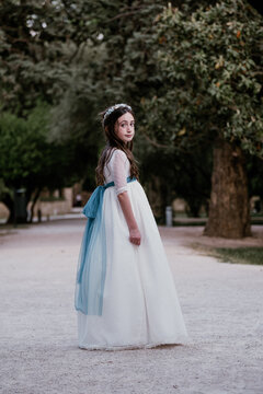 Elegant girl in white dress standing in park