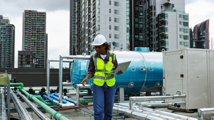 Fototapeta premium Female environment engineer with safety uniform with walkie-talkie using a smartphone working on the sideline