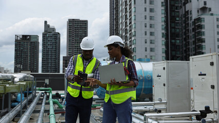 Male and Female engineer team working on the rooftop of a high building in City