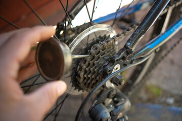 A hand with a metal oil can.Lubricate the chain on the bike.Preventive lubrication of the chain.