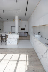 minimalistic modern luxury design of an expensive house with marble trim on a sunny day. white walls with plaster, parquet, decorative lighting and no one inside