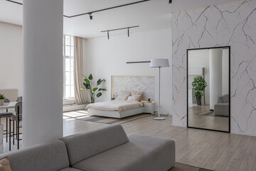 minimalistic modern luxury design of an expensive house with marble trim on a sunny day. white walls with plaster, parquet, decorative lighting and no one inside