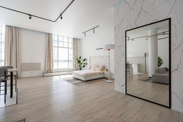 minimalistic modern luxury design of an expensive house with marble trim on a sunny day. white walls with plaster, parquet, decorative lighting and no one inside